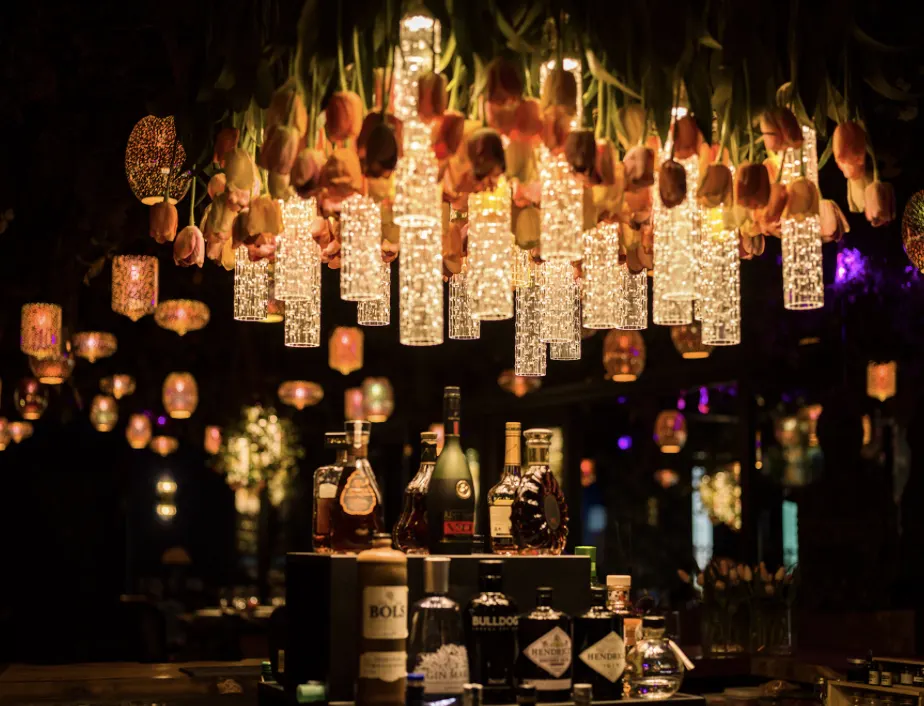 Barra de La Petite Forêt con cientos de lámparas colgantes de cristal iluminadas sobre las botellas