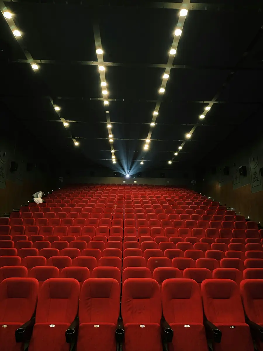 Butacas rojas vacías de un cine con el haz de luz del proyector