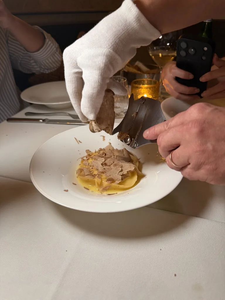 Raviolo con trufa rallándose al momento sobre el plato